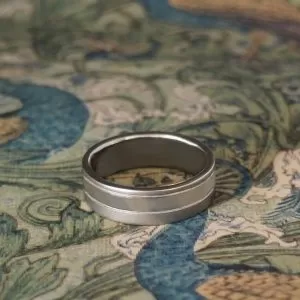 Titanium, 6mm flat profile with 3mm polished silver inlay off set with two fine grooves and brushed finish edges Size R 1/2 *