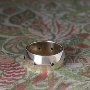 Captain - 9WG 11mm Central Bevelled Band with .16ct TW Gypsy Set Black Spinels Size Y